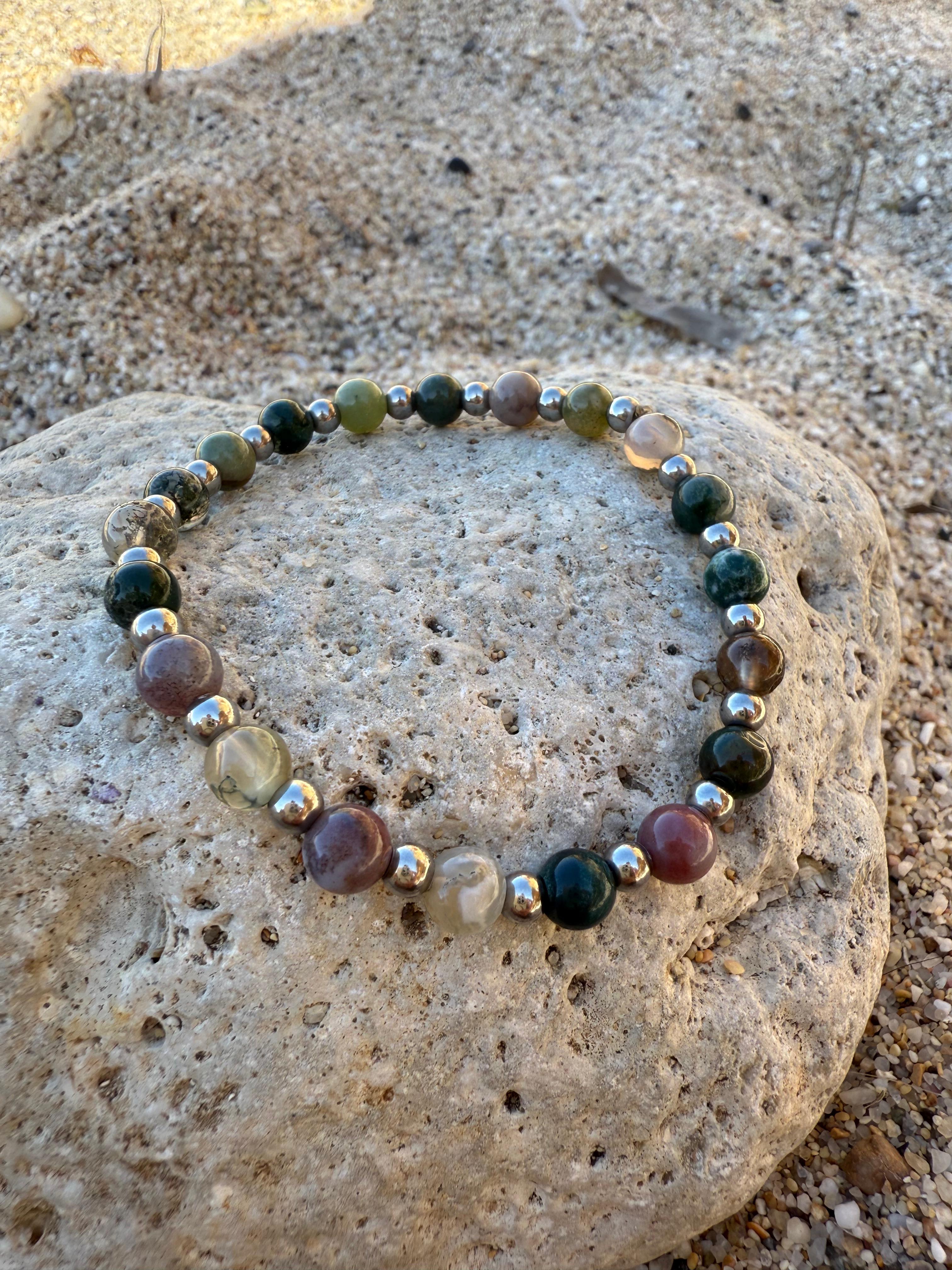 Bracciale fotografato tra roccia e sabbia