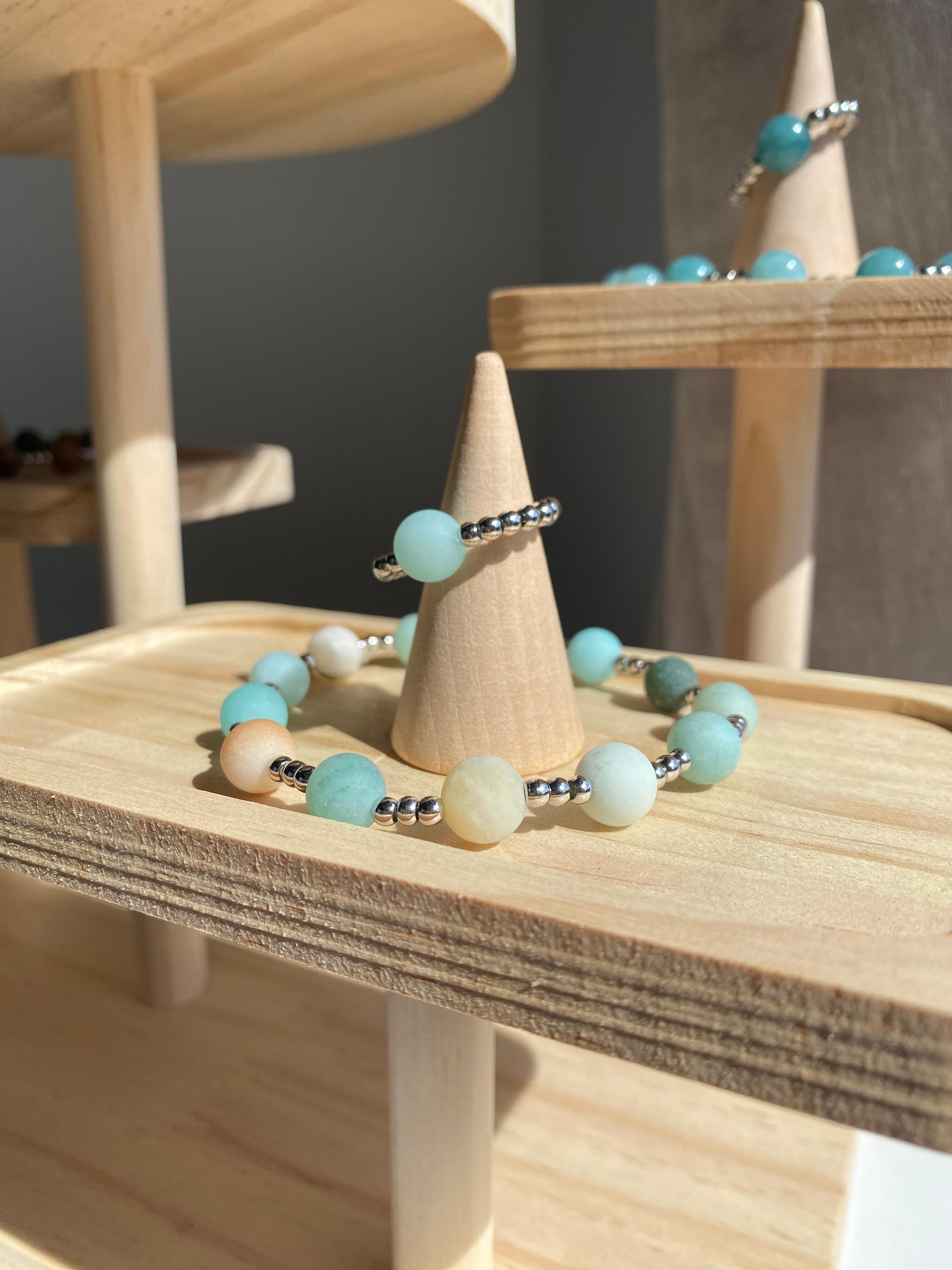 Esposizione di anelli e bracciali su supporti in legno